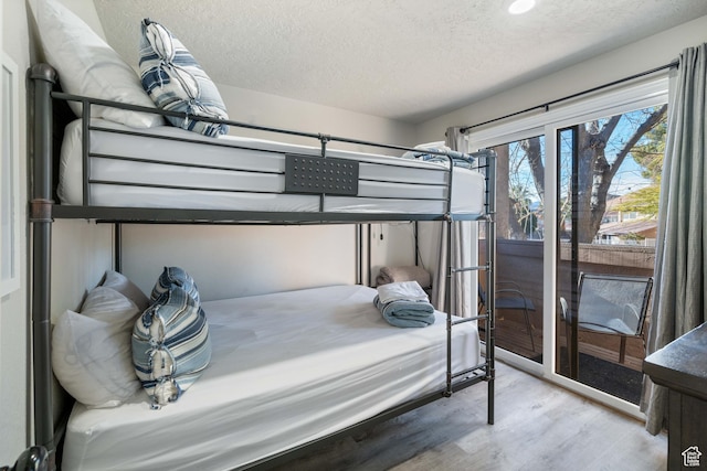 bedroom with light hardwood / wood-style flooring and a textured ceiling