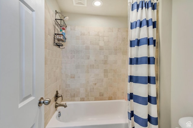 bathroom with shower / bath combo with shower curtain and visible vents