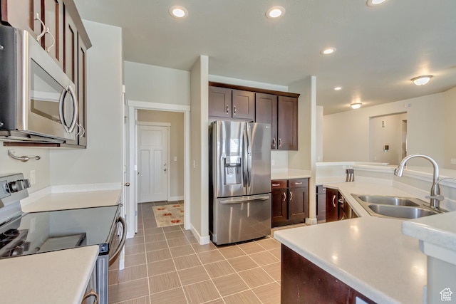 kitchen with recessed lighting, stainless steel appliances, light countertops, and a sink
