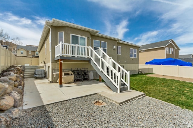 rear view of house featuring a patio, stairway, a fenced backyard, a lawn, and stucco siding