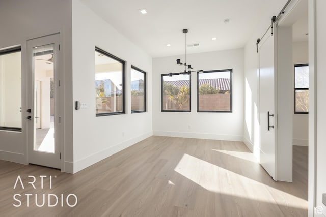 2752 S 3930 W, Hurricane, UT 84737 - unfurnished dining area with a barn door, plenty of natural light, and light hardwood / wood-style floors