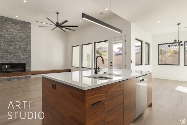 2752 S 3930 W, Hurricane, UT 84737 - kitchen featuring sink, a spacious island, a stone fireplace, stainless steel dishwasher, and light wood-type flooring