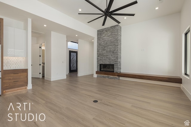 2752 S 3930 W, Hurricane, UT 84737 - unfurnished living room with ceiling fan, a stone fireplace, and light hardwood / wood-style floors