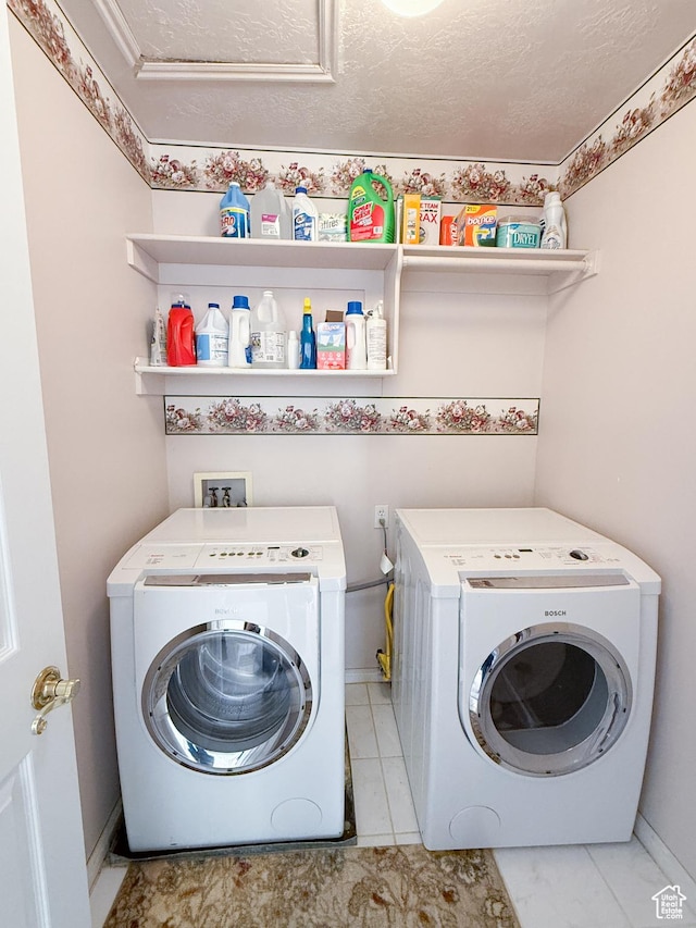 washroom featuring washing machine and dryer and a textured ceiling