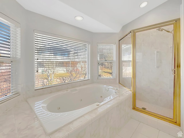 bathroom featuring shower with separate bathtub, vaulted ceiling, and tile patterned floors