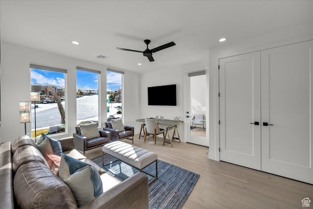 living room featuring ceiling fan and light wood-type flooring