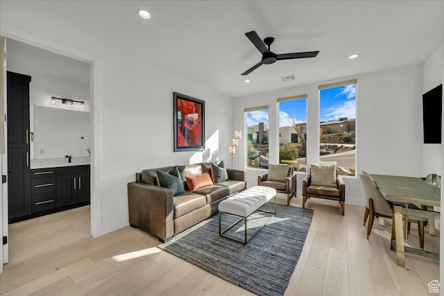 living room featuring ceiling fan and light hardwood / wood-style floors