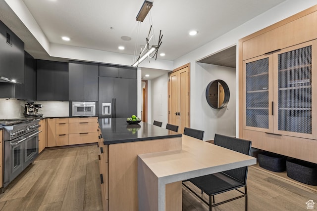 1271 Lowell Ave Unit B202, Park City, UT 84060 - kitchen with pendant lighting, range with two ovens, a kitchen island, light brown cabinetry, and light wood-type flooring