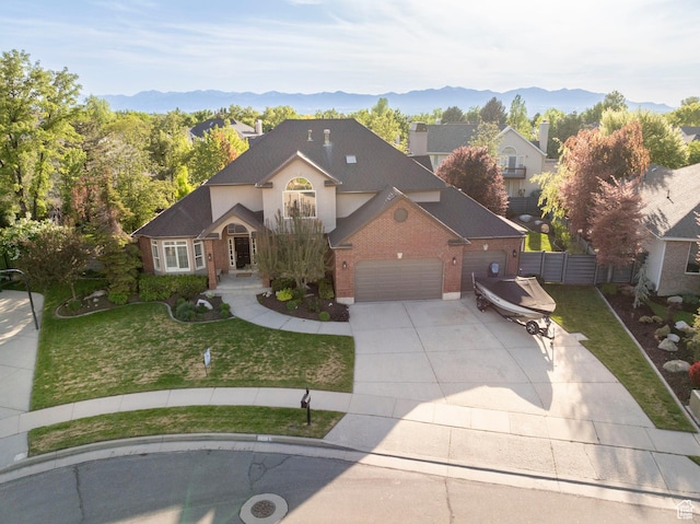 6658 S Caracol Cv, Cottonwood Heights, UT 84121 - traditional-style house featuring driveway, an attached garage, brick siding, and a mountain view