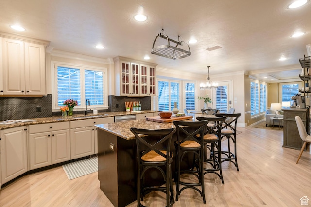 6658 S Caracol Cv, Cottonwood Heights, UT 84121 - kitchen with a sink, light wood-type flooring, crown molding, tasteful backsplash, and a center island