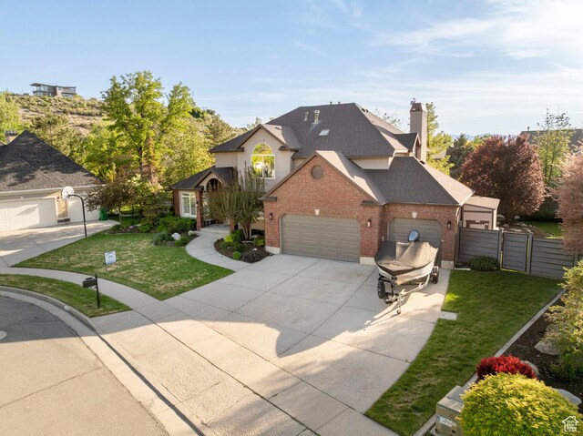 6658 S Caracol Cv, Cottonwood Heights, UT 84121 - traditional-style home with brick siding, driveway, an attached garage, roof with shingles, and a gate