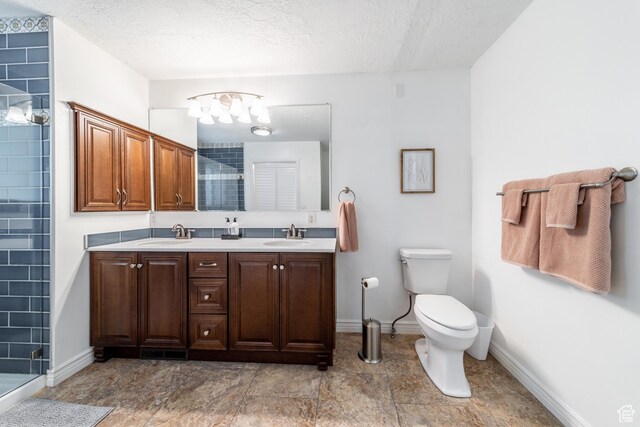 1097 E Thrushwood Dr, Logan, UT 84321 - bathroom featuring a shower with door, vanity, a textured ceiling, and toilet