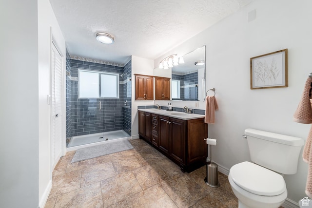 1097 E Thrushwood Dr, Logan, UT 84321 - bathroom with a tile shower, vanity, a textured ceiling, and toilet