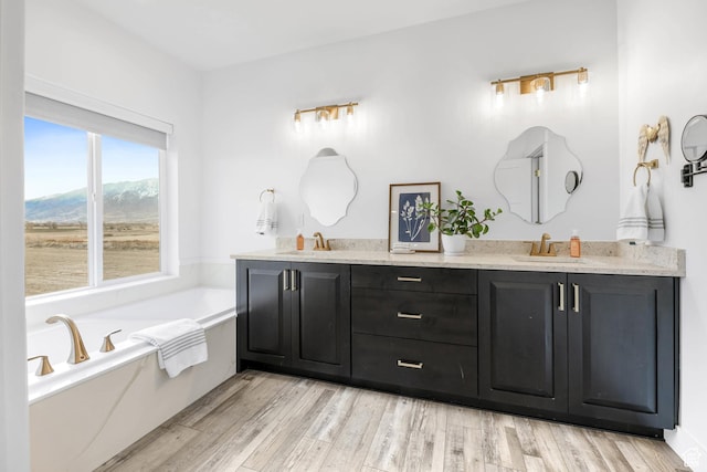 3932 W 2875 N, Plain City, UT 84404 - bathroom with wood finished floors, double vanity, and a garden tub