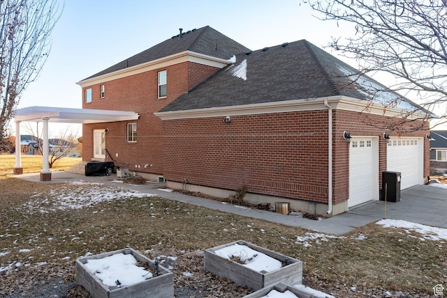 434 S Cardon Ridge Dr, Smithfield, UT 84335 - view of property exterior featuring a shingled roof, brick siding, a garage, and concrete driveway