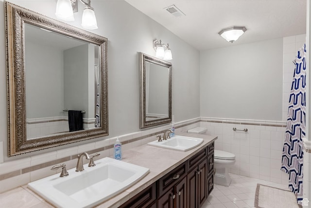 434 S Cardon Ridge Dr, Smithfield, UT 84335 - full bathroom with toilet, tile walls, double vanity, tile patterned floors, and a wainscoted wall