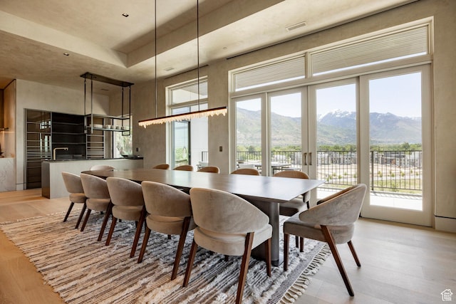 1920 E Rodeo Walk Dr Unit 516, Holladay, UT 84117 - dining space with light wood-style flooring, a mountain view, healthy amount of natural light, and a towering ceiling
