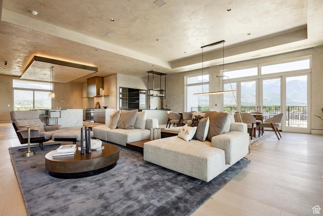 1920 E Rodeo Walk Dr Unit 516, Holladay, UT 84117 - living area featuring a tray ceiling, wood finished floors, and a mountain view