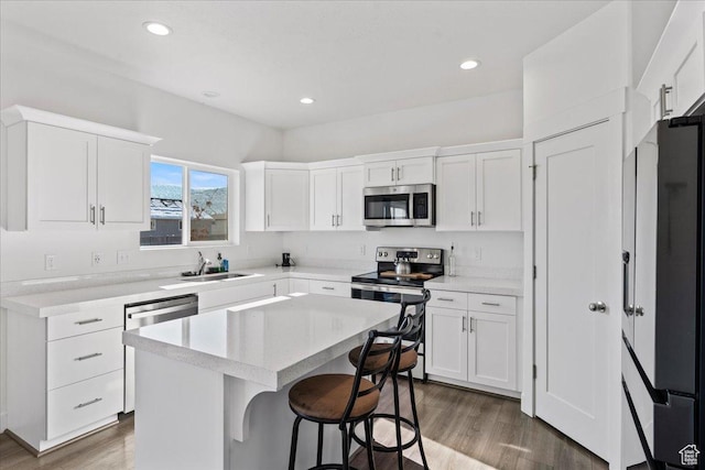 4590 E Silver Moon Dr Unit 3007, Eagle Mountain, UT 84005 - kitchen with sink, appliances with stainless steel finishes, a kitchen breakfast bar, a center island, and white cabinets