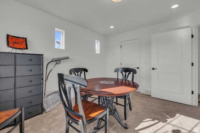 dining space featuring light carpet