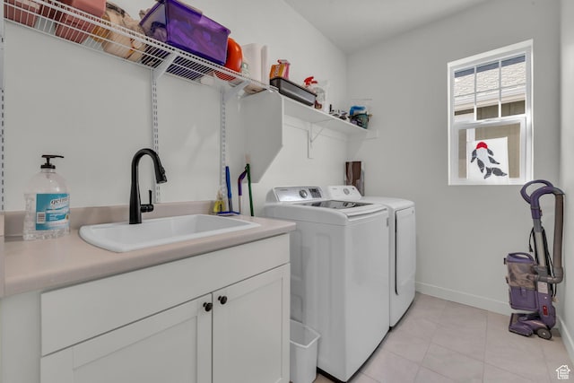 laundry area featuring cabinets, light tile patterned flooring, sink, and independent washer and dryer
