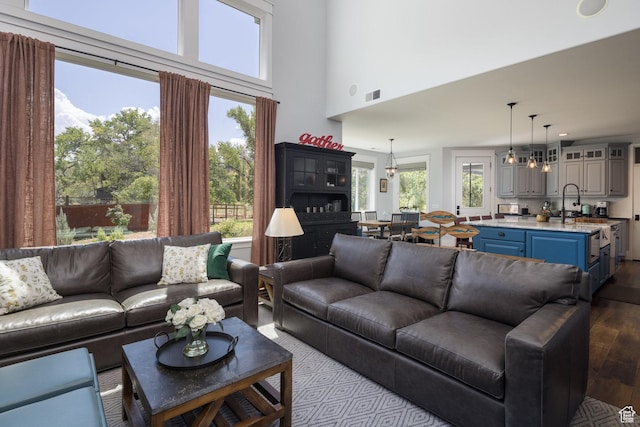 424 E Secret Cove Ct, Moab, UT 84532 - living room with visible vents, dark wood finished floors, and a towering ceiling