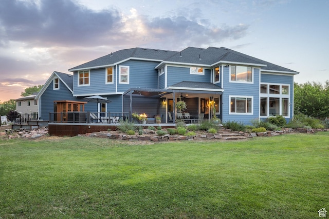 424 E Secret Cove Ct, Moab, UT 84532 - back of property at dusk with a patio, a ceiling fan, a yard, and a shingled roof