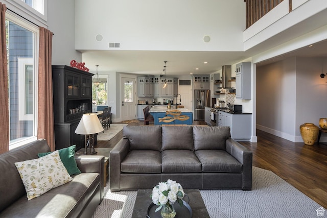 424 E Secret Cove Ct, Moab, UT 84532 - living area featuring dark wood-type flooring, baseboards, a towering ceiling, and visible vents
