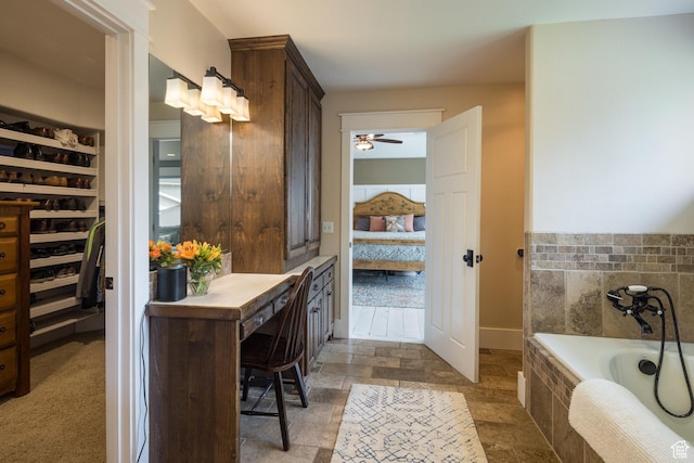 424 E Secret Cove Ct, Moab, UT 84532 - full bath featuring ceiling fan, a walk in closet, stone finish floor, connected bathroom, and a bath