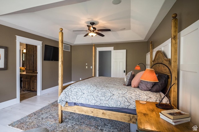 424 E Secret Cove Ct, Moab, UT 84532 - bedroom with visible vents, ensuite bathroom, wood finished floors, and a tray ceiling