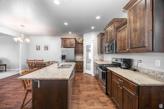 644 E 50 S, Hyrum, UT 84319 - kitchen featuring appliances with stainless steel finishes, a sink, a kitchen bar, recessed lighting, and a kitchen island with sink