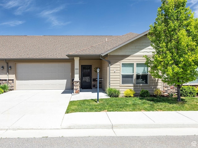 644 E 50 S, Hyrum, UT 84319 - view of front of property with an attached garage, driveway, a shingled roof, stone siding, and a front lawn
