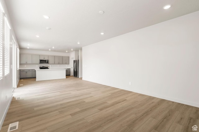 3141 W 3500 S Unit 113, West Haven, UT 84401 - unfurnished living room featuring recessed lighting, baseboards, visible vents, and light wood finished floors