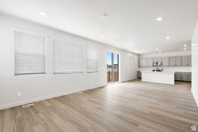 3141 W 3500 S Unit 113, West Haven, UT 84401 - unfurnished living room with light wood-style floors, baseboards, recessed lighting, and visible vents