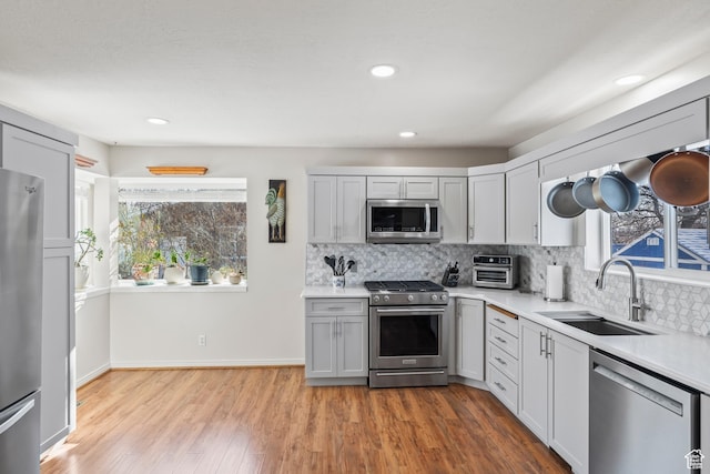 kitchen featuring sink, plenty of natural light, stainless steel appliances, and light wood-type flooring