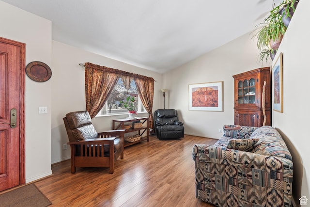 living area with lofted ceiling and hardwood / wood-style floors