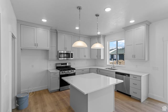 kitchen featuring gray cabinetry, sink, stainless steel appliances, and a kitchen island