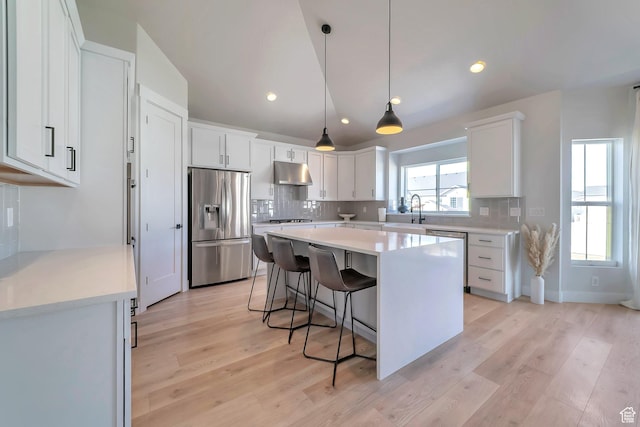 1521 E Thorpe Dr, Eagle Mountain, UT 84005 - kitchen featuring under cabinet range hood, a sink, tasteful backsplash, a center island, and appliances with stainless steel finishes