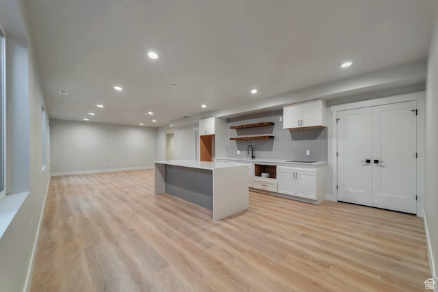 1521 E Thorpe Dr, Eagle Mountain, UT 84005 - kitchen featuring white cabinetry, a sink, light wood-style floors, and a kitchen island