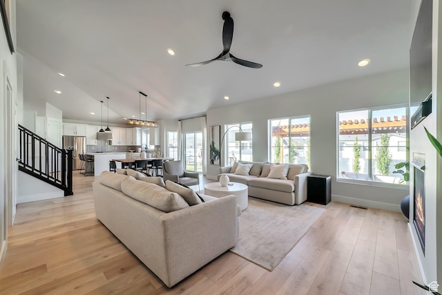 1521 E Thorpe Dr, Eagle Mountain, UT 84005 - living room featuring light wood finished floors, ceiling fan, stairs, lofted ceiling, and recessed lighting