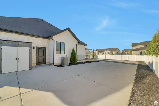 1521 E Thorpe Dr, Eagle Mountain, UT 84005 - back of house with a residential view, central AC, stucco siding, a fenced backyard, and a patio area