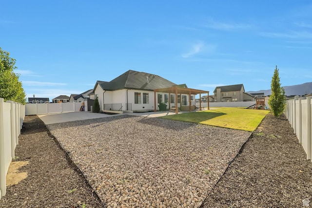 1521 E Thorpe Dr, Eagle Mountain, UT 84005 - rear view of house featuring a patio, a fenced backyard, stucco siding, a playground, and a lawn