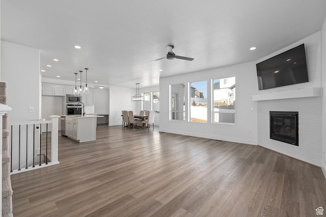 1504 S Lukas Ln, Saratoga Springs, UT 84045 - unfurnished living room with ceiling fan with notable chandelier and dark wood-type flooring