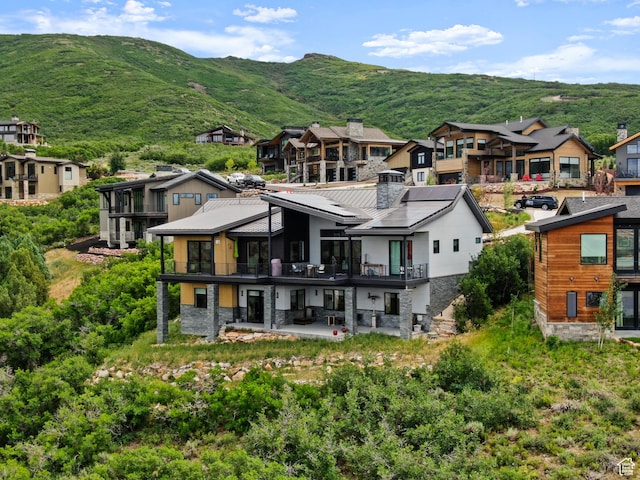 11515 N White Tail Ct, Hideout, UT 84036 - back of house featuring stone siding, a patio, and a residential view