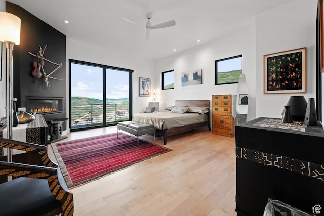 11515 N White Tail Ct, Hideout, UT 84036 - bedroom featuring a glass covered fireplace, access to outside, light wood finished floors, and recessed lighting