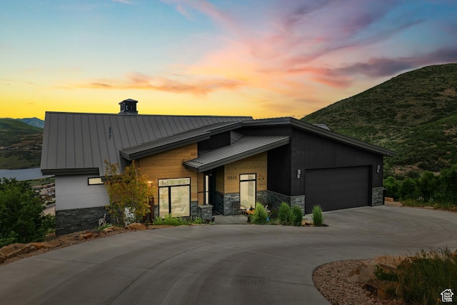 11515 N White Tail Ct, Hideout, UT 84036 - modern home with stone siding, an attached garage, and metal roof