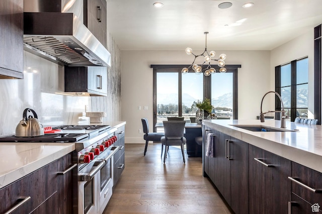 149 N Haystack Mountain Dr, Heber City, UT 84032 - kitchen with double oven range, wall chimney range hood, a sink, light countertops, and modern cabinets