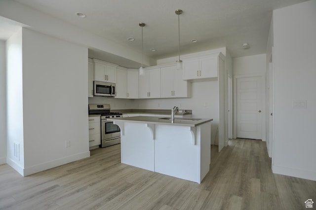 kitchen featuring white cabinetry, appliances with stainless steel finishes, sink, and a center island with sink