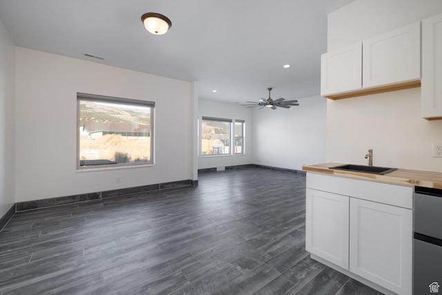 7748 W Mountain Dell Dr, Vernal, UT 84078 - interior space featuring butcher block counters, sink, white cabinetry, dark hardwood / wood-style floors, and dishwashing machine