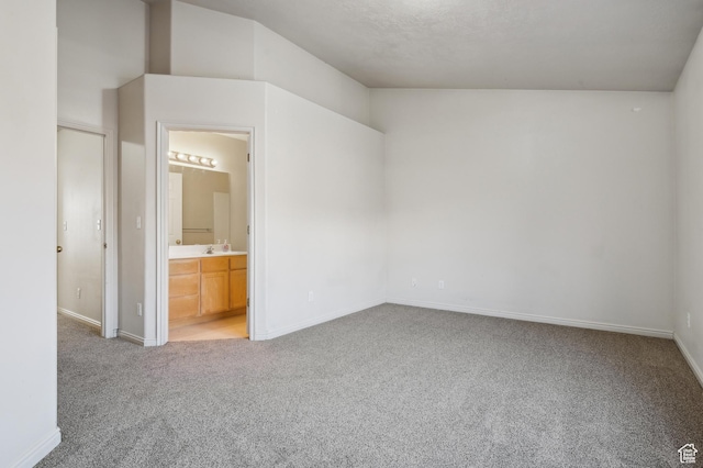 unfurnished bedroom with carpet, sink, and ensuite bath